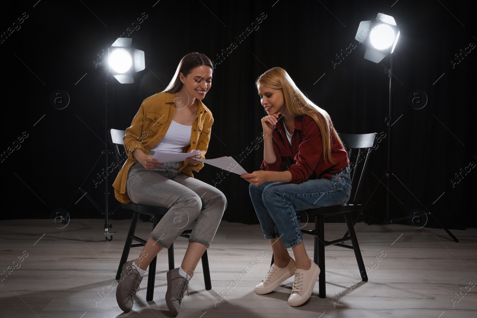 Photo of Professional actresses reading their scripts during rehearsal in theatre