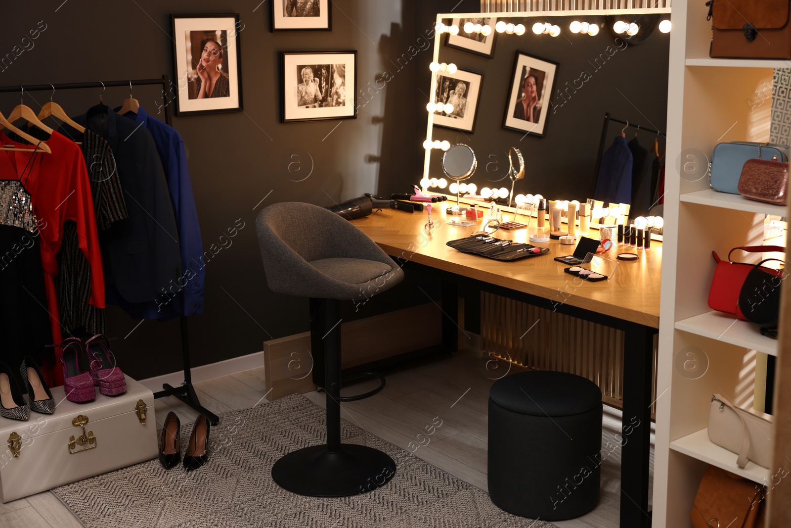 Photo of Chair, clothes rack and stylish mirror on dressing table in makeup room