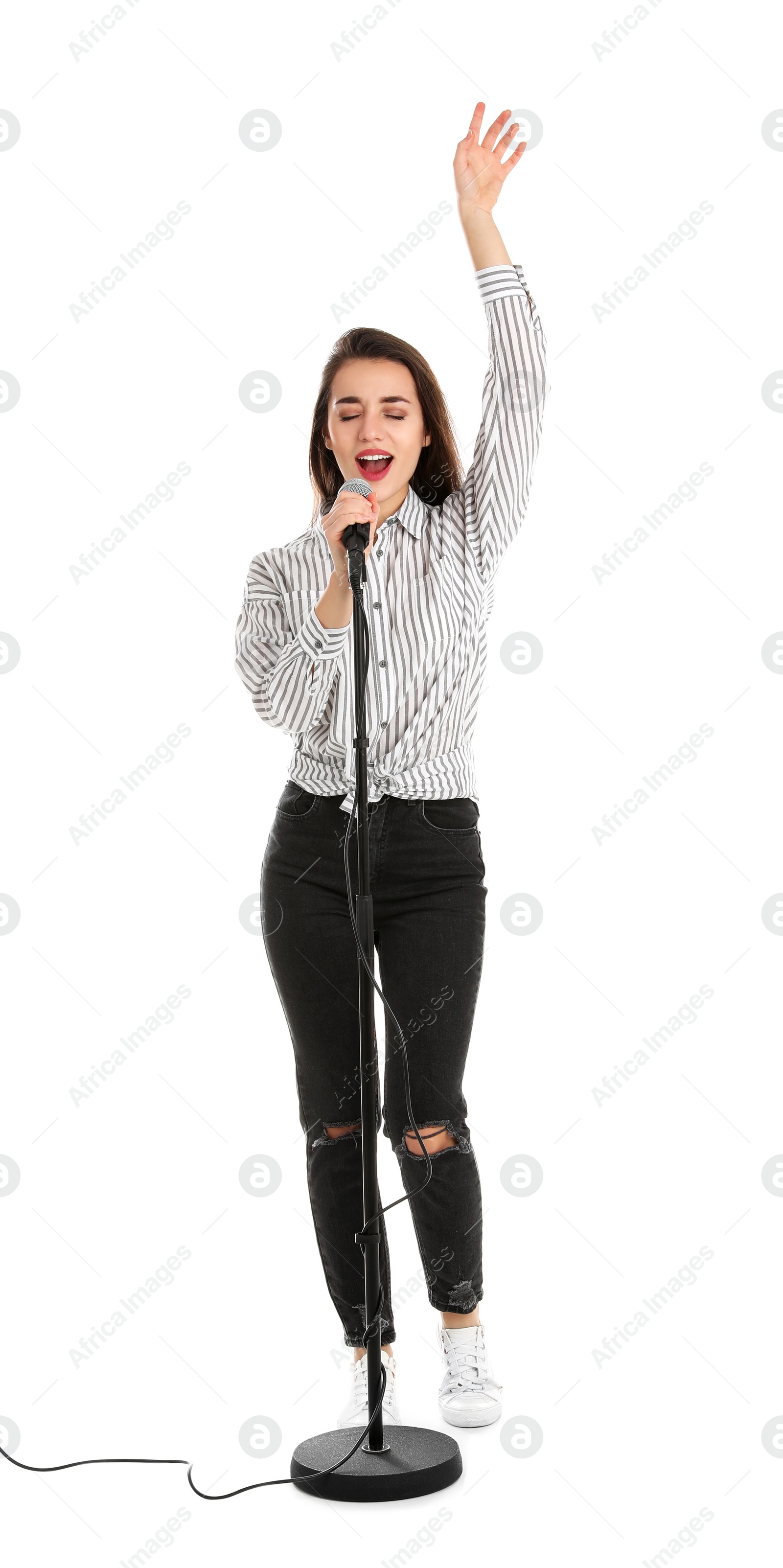 Photo of Young woman in casual clothes singing with microphone on white background