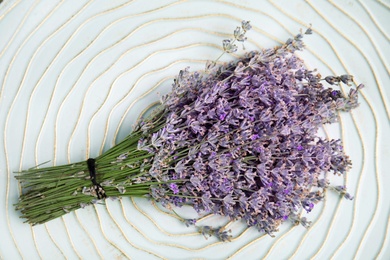 Beautiful blooming lavender flowers on plate, top view