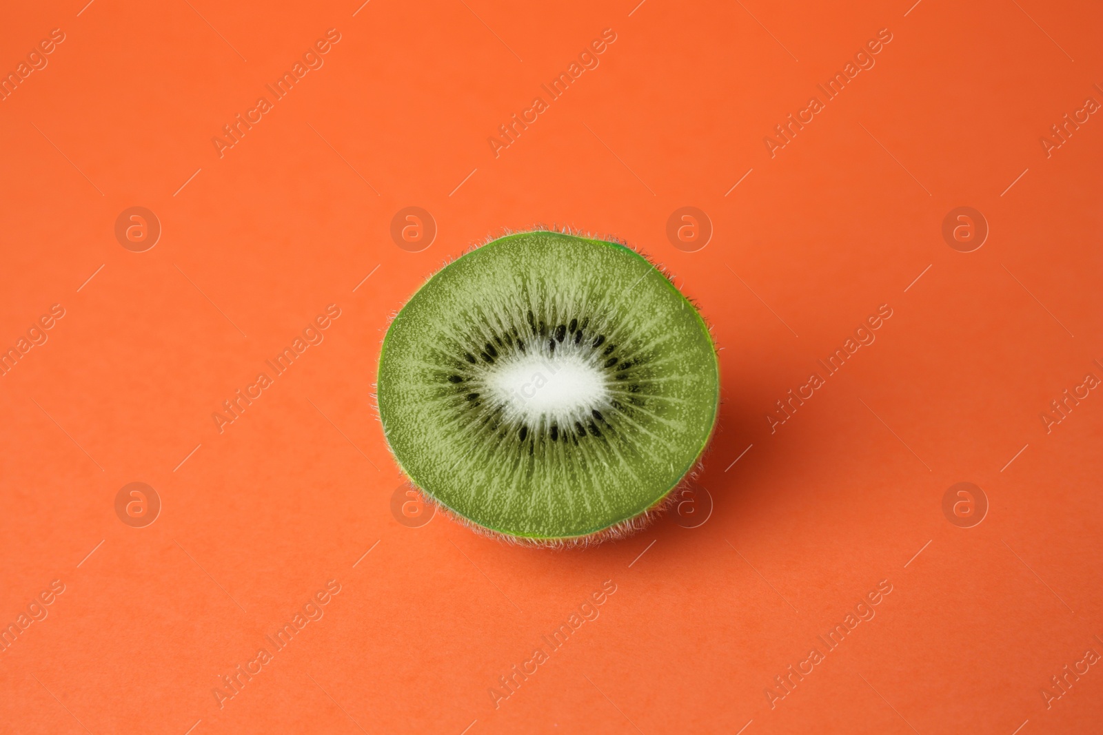 Photo of Cut fresh ripe kiwi on orange background