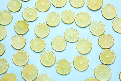 Photo of Juicy fresh lime slices on light blue background, flat lay
