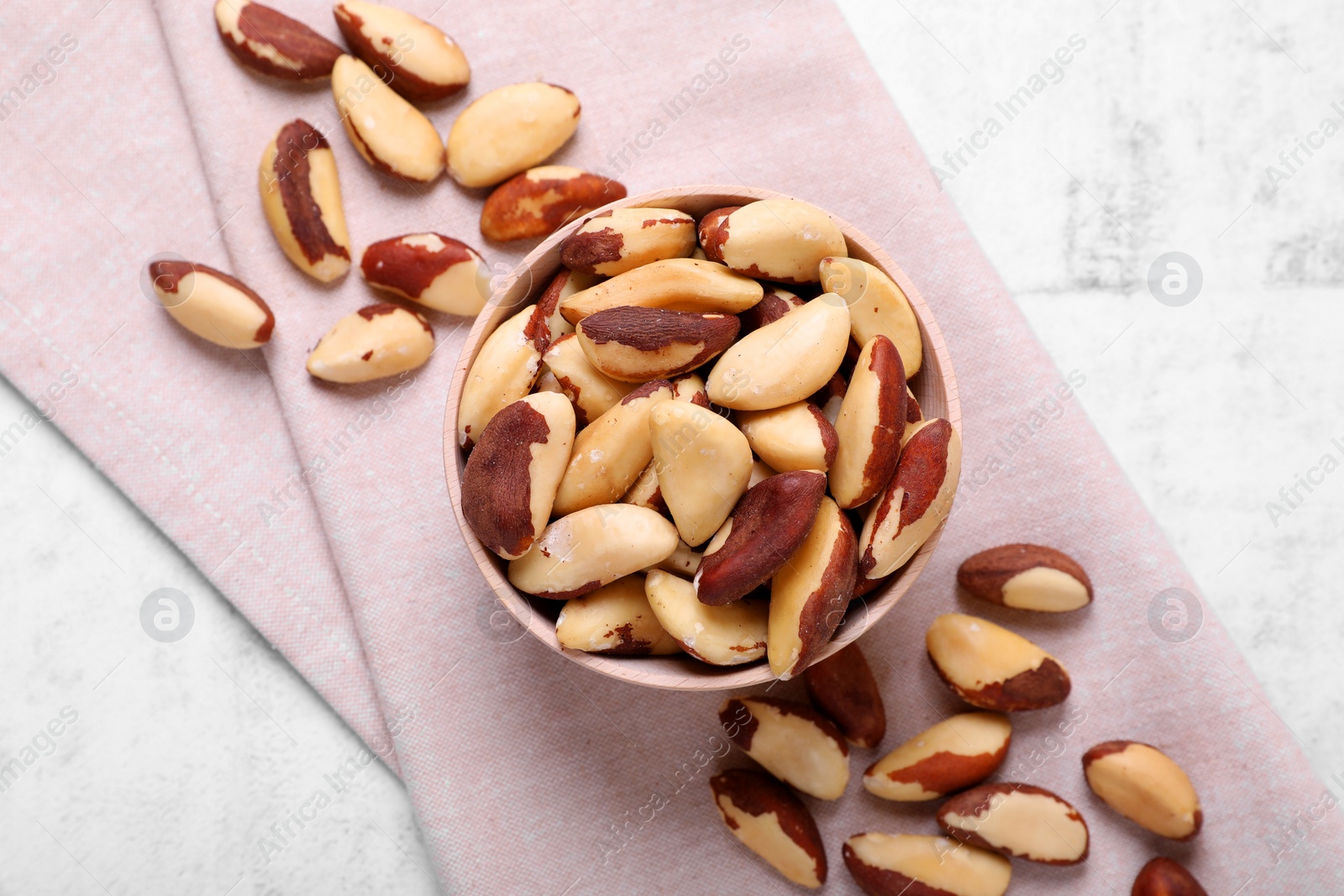 Photo of Delicious Brazil nuts on white table, flat lay