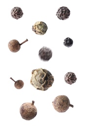 Image of Many different peppercorns falling on white background