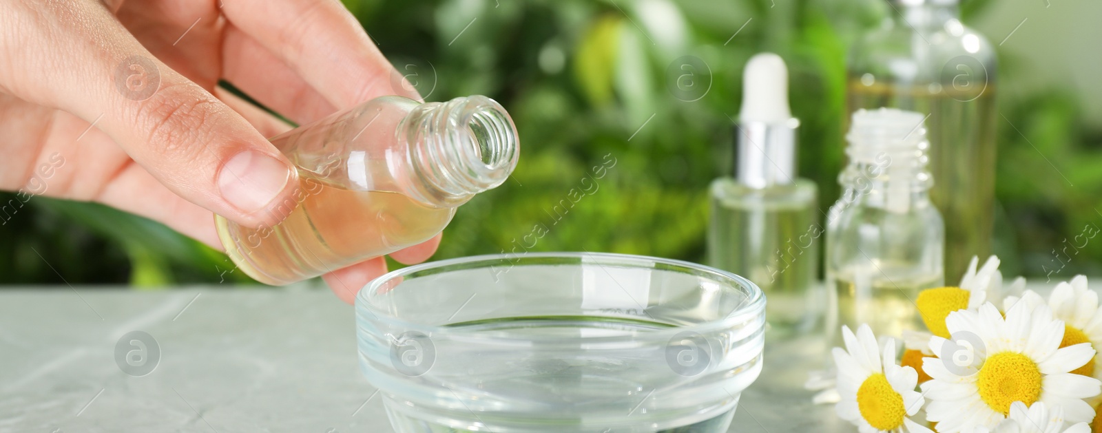 Image of Woman dripping essential oil into bowl, closeup. Banner design