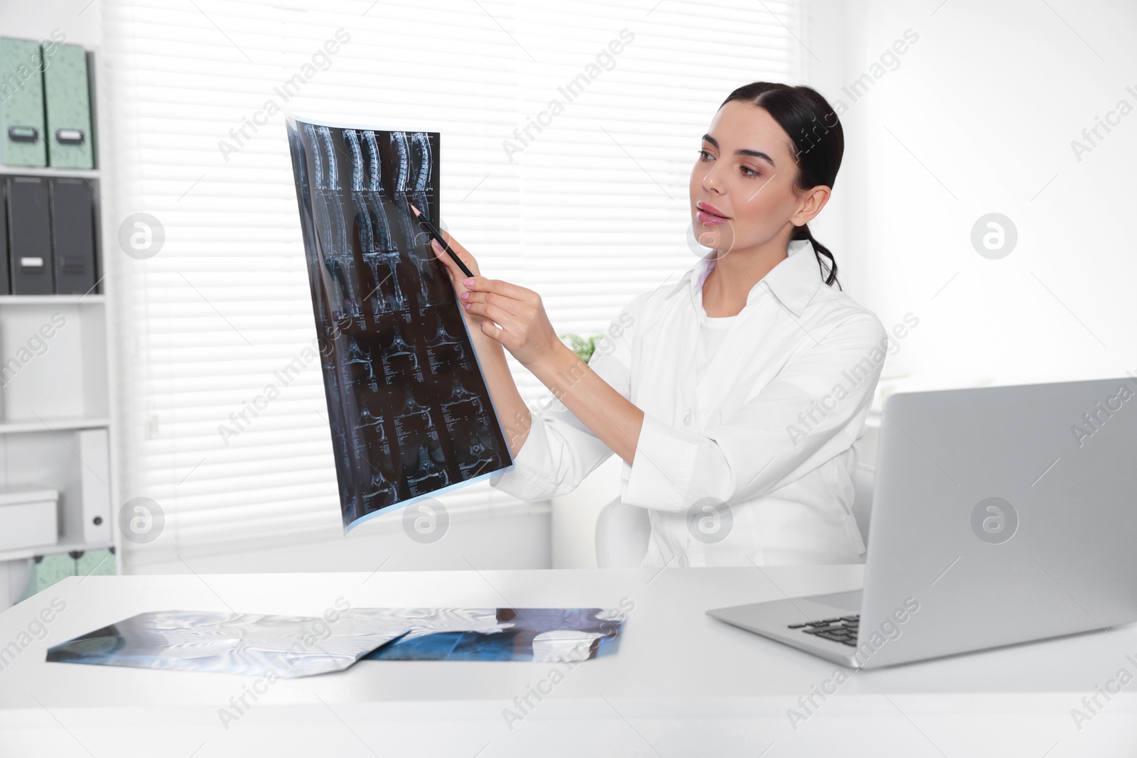 Photo of Doctor examining neck MRI image in clinic