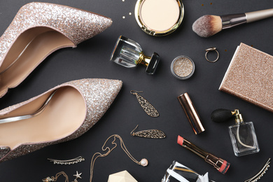 Flat lay composition with cosmetics and stylish accessories on black background