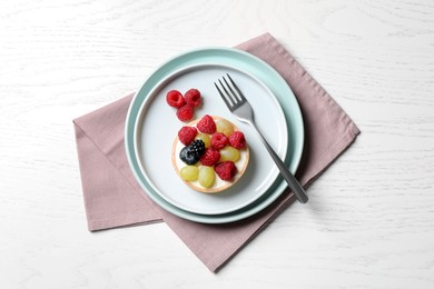 Delicious tartlet with berries on white wooden table, top view