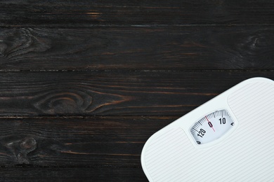Photo of Scales on wooden background, top view with space for text. Weight loss