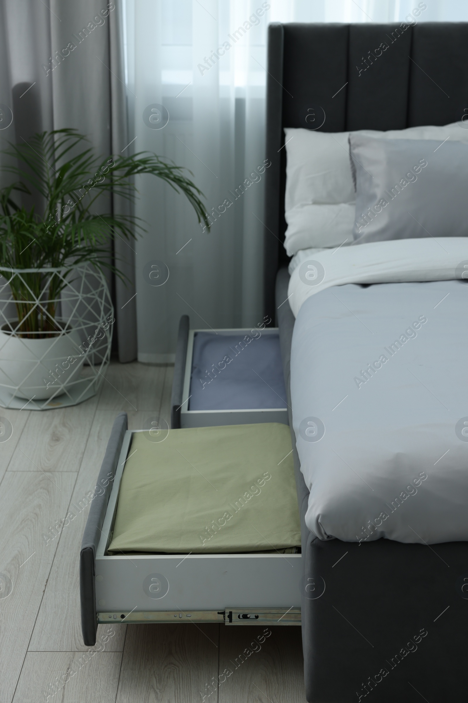 Photo of Storage drawers with bedding under modern bed in room