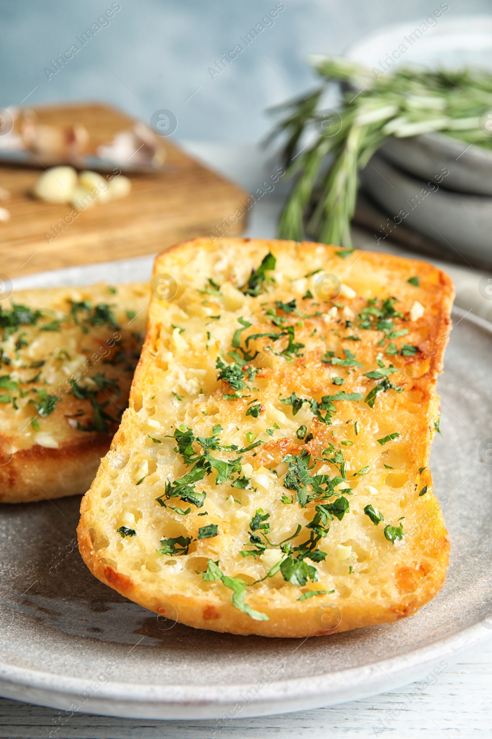 Photo of Plate with delicious homemade garlic bread on table