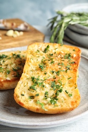 Photo of Plate with delicious homemade garlic bread on table