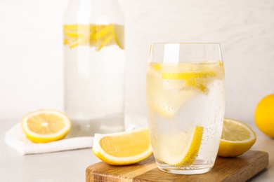 Soda water with lemon slices on light table. Space for text