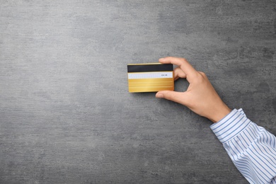 Photo of Young woman holding credit card over table