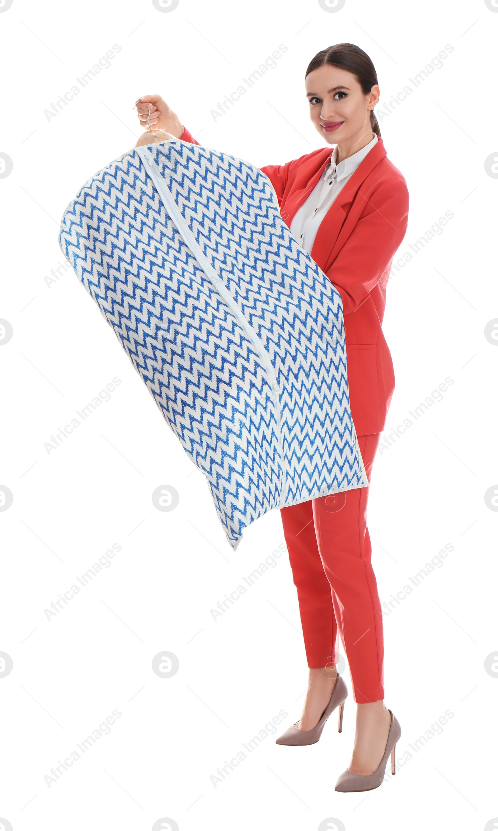 Photo of Young woman holding hanger with clothes in garment cover on white background. Dry-cleaning service