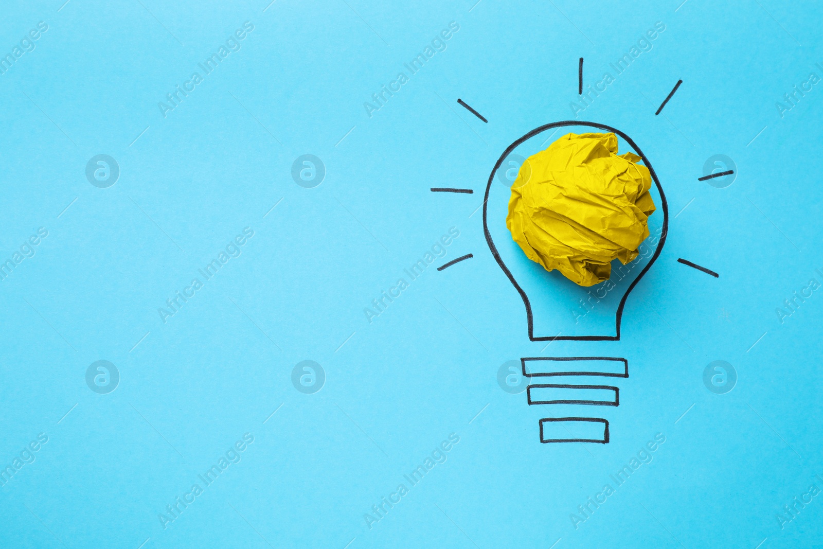 Photo of Idea concept. Light bulb made with crumpled paper and drawing on light blue background, top view. Space for text