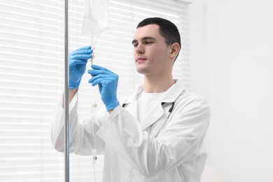 Photo of Doctor setting up IV drip in hospital