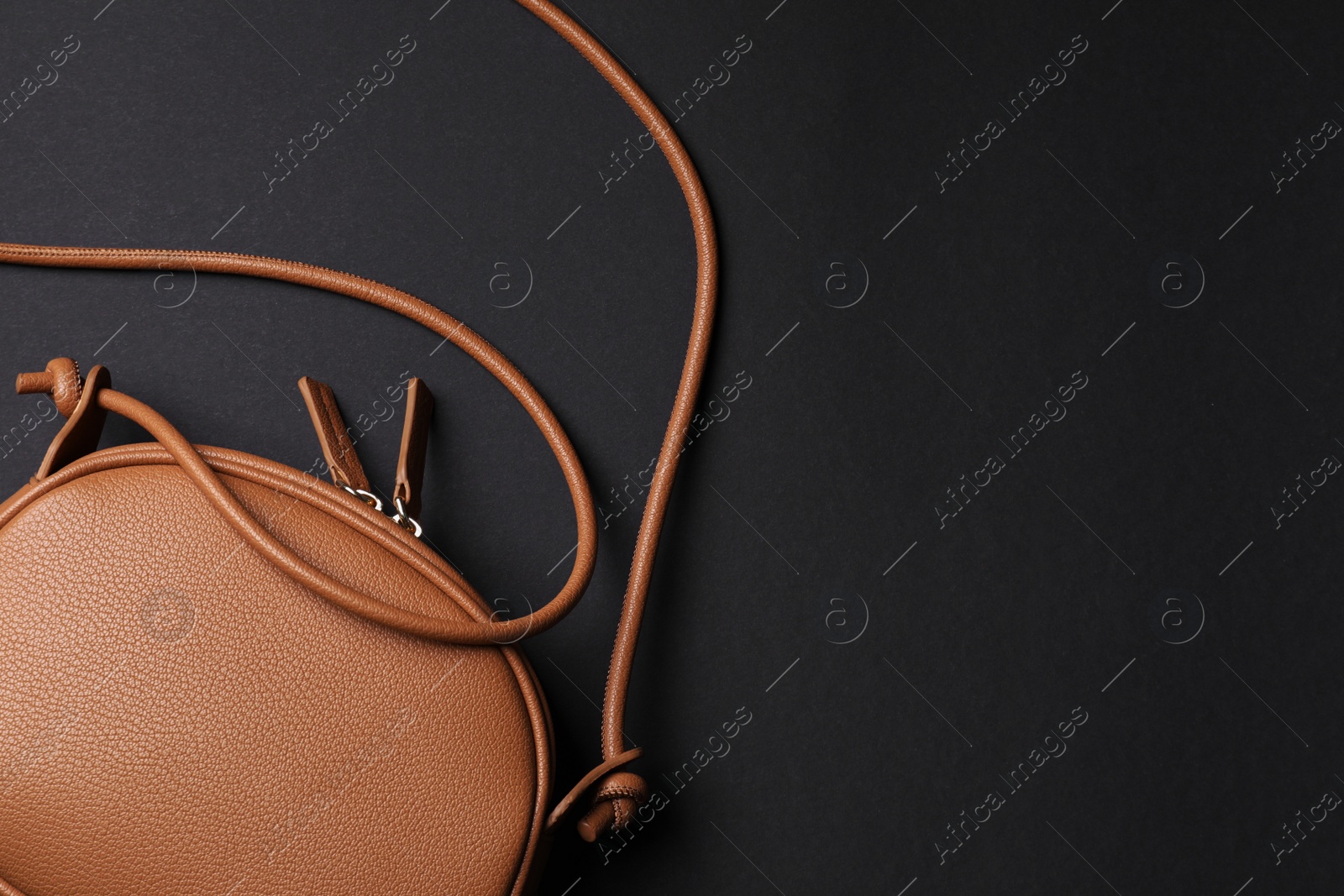 Photo of Stylish woman's bag on black background, top view. Space for text