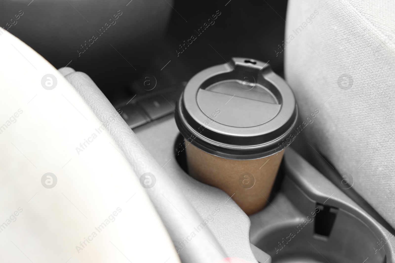 Photo of Coffee to go. Paper cup with tasty drink in holder inside of car, closeup
