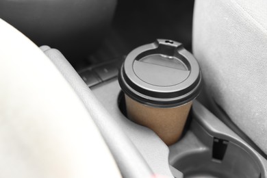 Coffee to go. Paper cup with tasty drink in holder inside of car, closeup