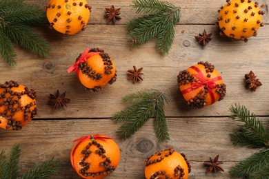 Photo of Flat lay composition with pomander balls made of fresh tangerines and oranges on wooden table