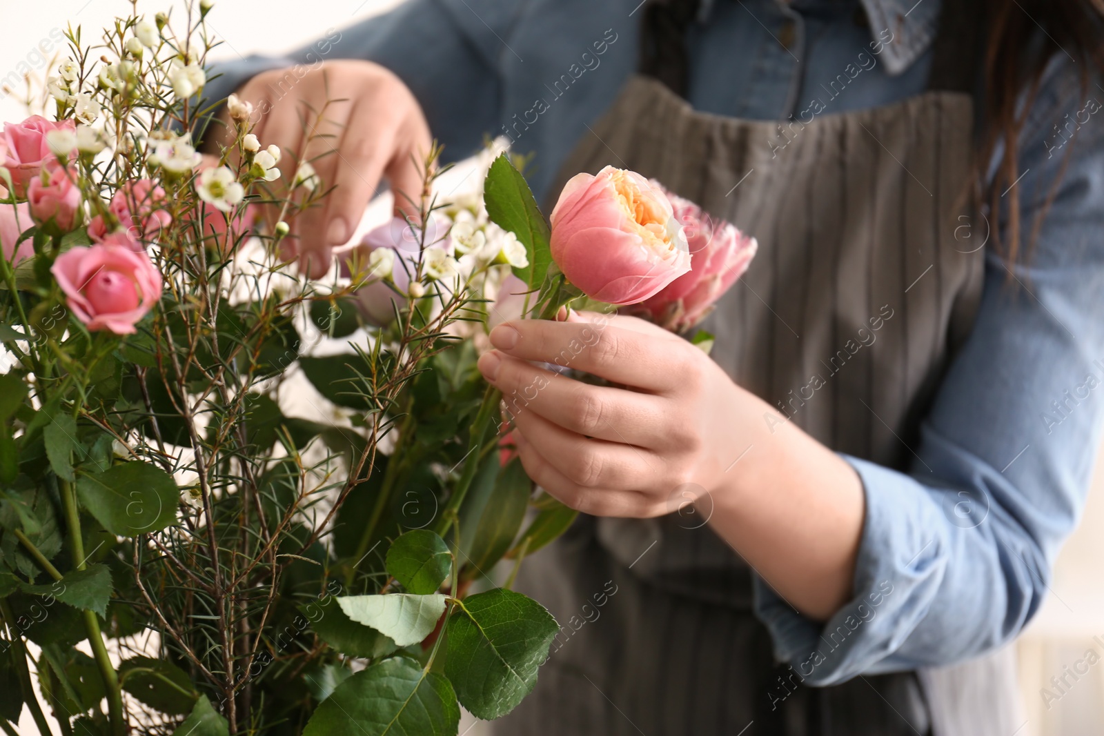 Photo of Female florist creating beautiful bouquet, closeup