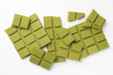 Photo of Pieces of tasty matcha chocolate bars on white background, top view