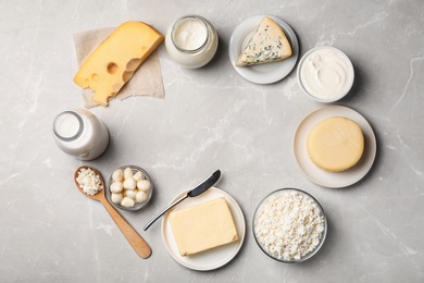 Photo of Frame of fresh dairy products on gray background, top view