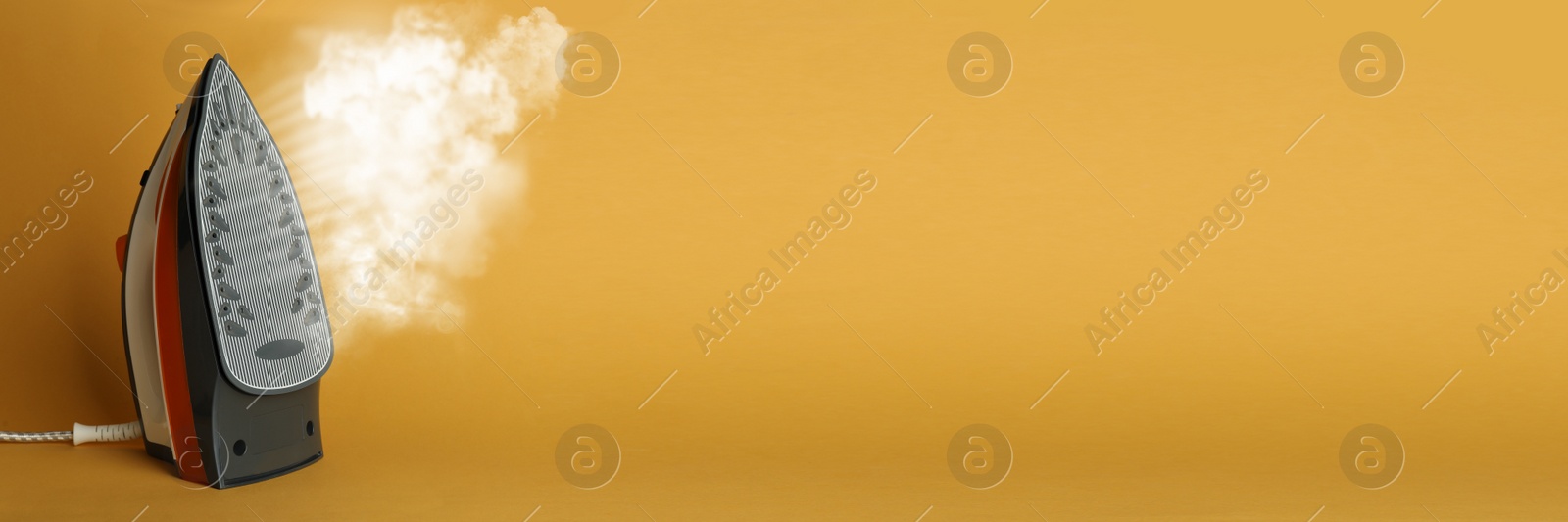 Image of Modern iron with steam on orange background, space for text. Banner design