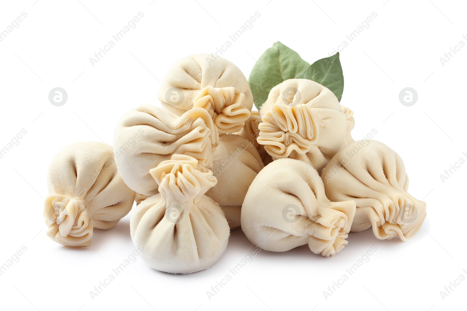 Photo of Pile of raw dumplings with bay leaves on white background