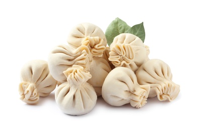 Photo of Pile of raw dumplings with bay leaves on white background