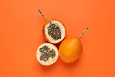 Photo of Delicious ripe granadillas on orange background, flat lay