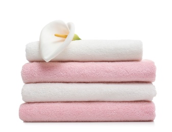 Photo of Stack of clean folded towels with flower on white background