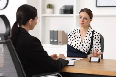 Photo of Injured woman having meeting with lawyer in office