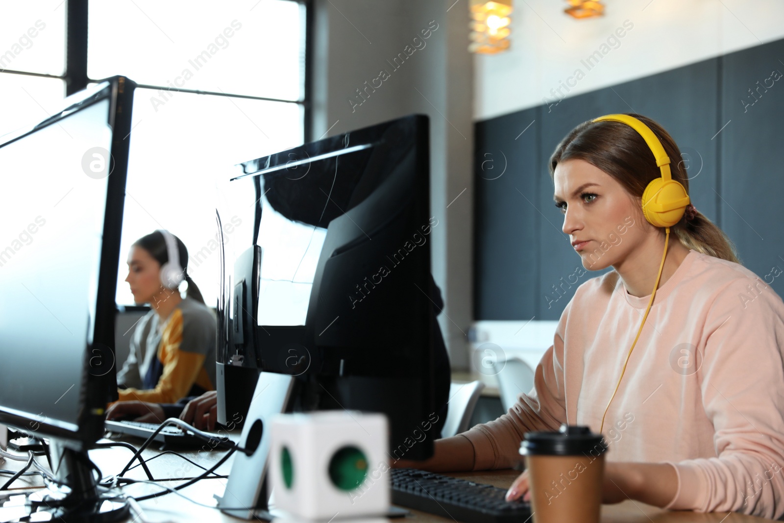 Photo of Woman playing video game in internet cafe