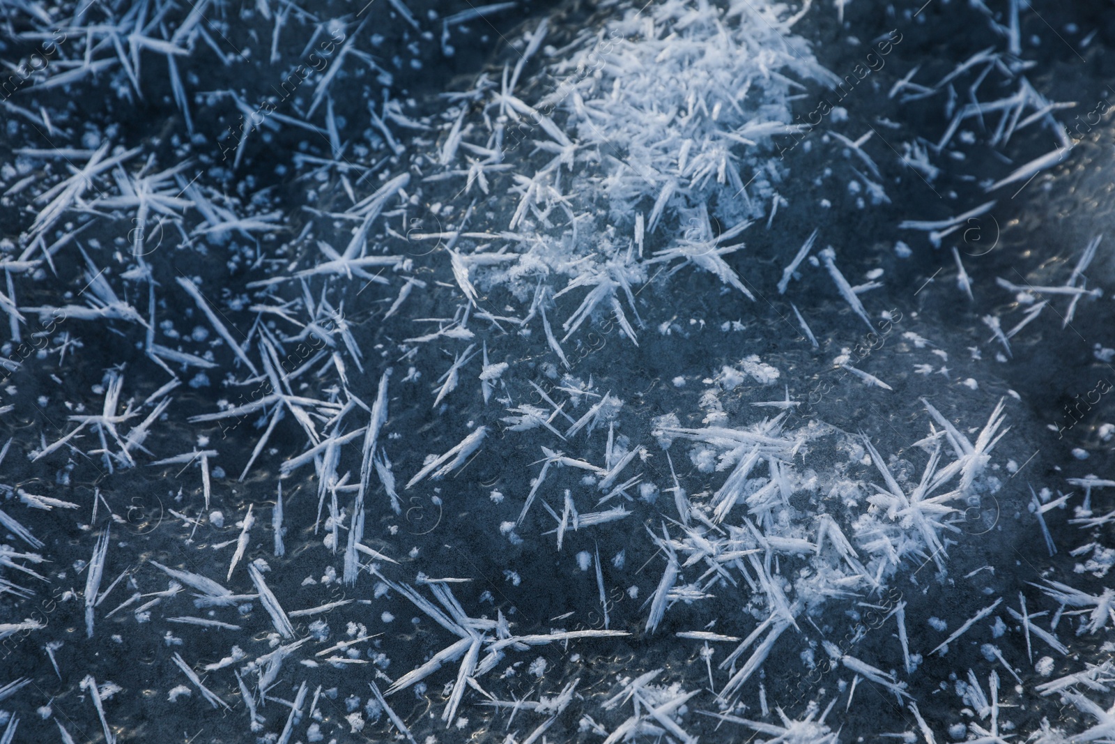 Photo of Hoarfrost crystals on icy surface, closeup view