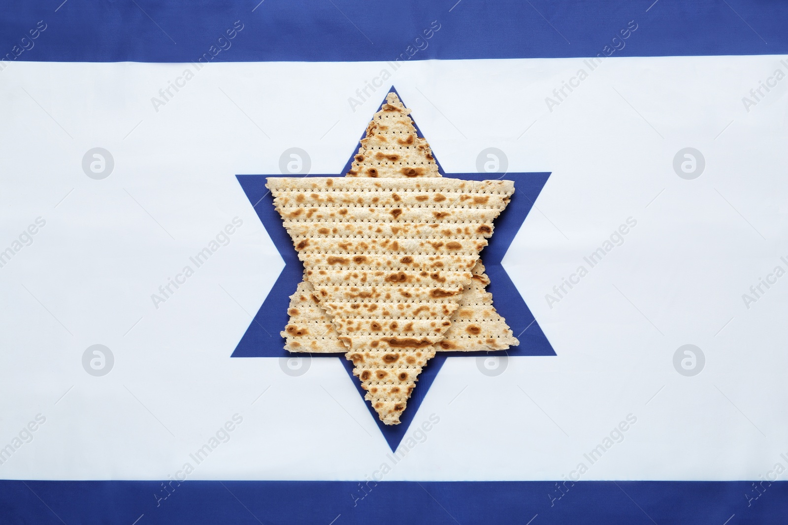 Photo of Star of David made with passover matzos on Israel flag, top view