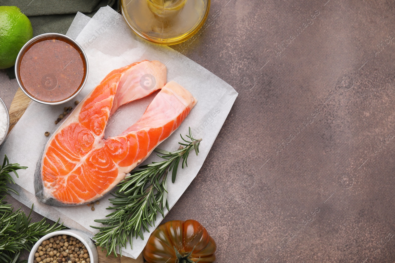 Photo of Fresh fish, products and marinade on brown textured table, flat lay. Space for text