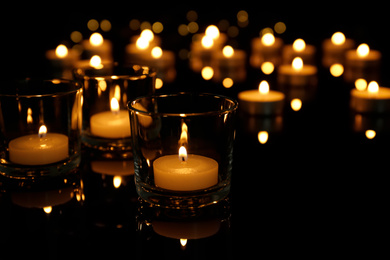 Burning candles in glass holders on table