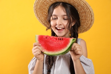 Photo of Cute little girl with watermelon on yellow background