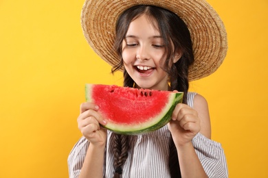 Cute little girl with watermelon on yellow background