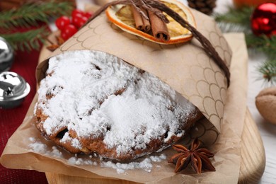 Photo of Traditional Christmas Stollen with icing sugar on table, closeup