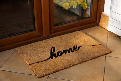 Photo of Doormat with word Home near entrance outdoors
