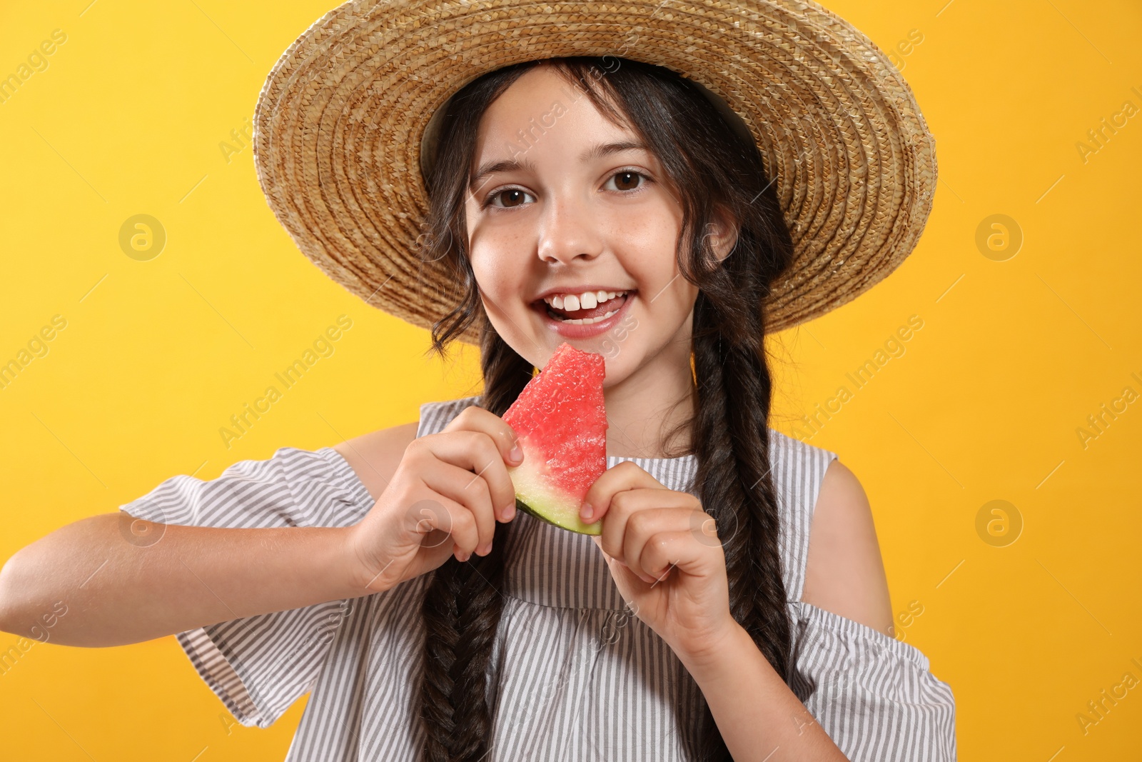 Photo of Cute little girl with watermelon on yellow background