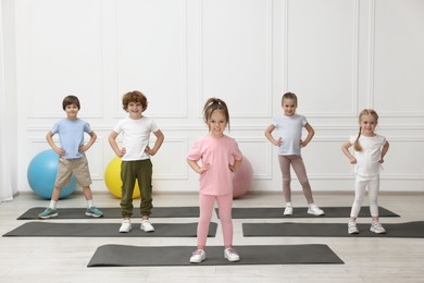 Photo of Group of children doing gymnastic exercises on mats indoors