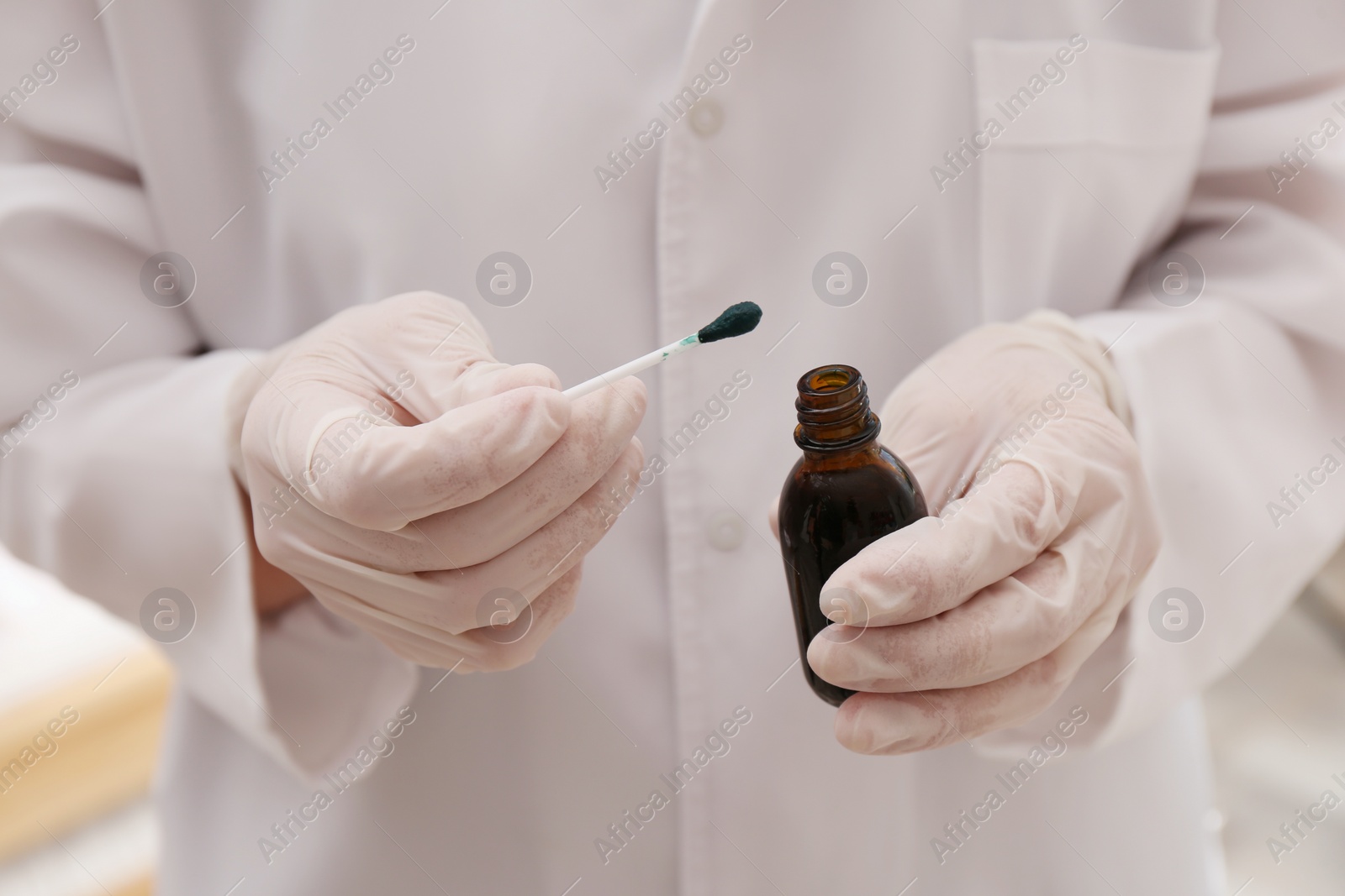 Photo of Doctor holding bottle of brilliant green and cotton bud, closeup