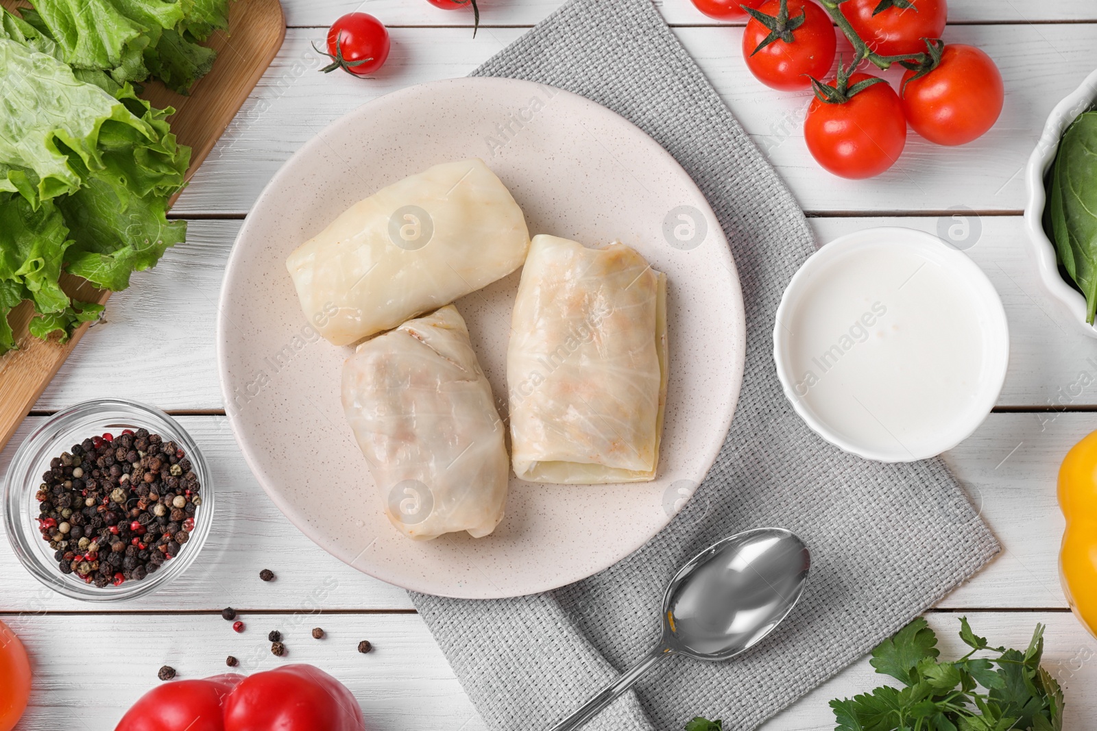 Photo of Delicious cabbage rolls served on white wooden table, flat lay