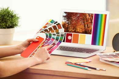 Professional female designer working with color palette samples and laptop at desk, closeup 