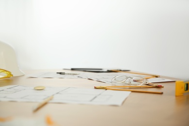 Photo of Drawings, construction tools and glasses on table in office, closeup