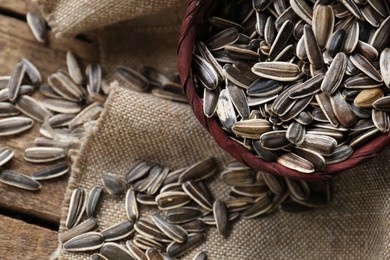 Photo of Organic sunflower seeds on wooden table, flat lay. Space for text